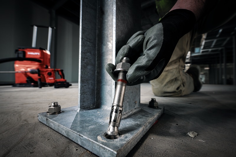 Working inserting Hilti HST4-R anchor in hole to fix base plate.